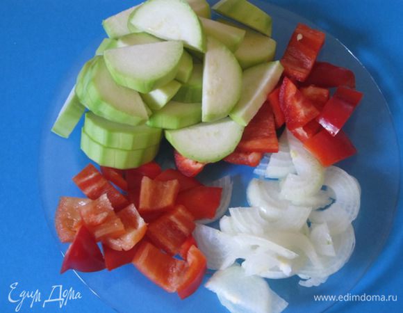 Для начинки овощи вымыть. Лук и кабачок очистить. У перца удалить сердцевину, крупно нарезать. Лук нарезать полукольцами, кабачки нарезать кружочками, а потом на 4 части.