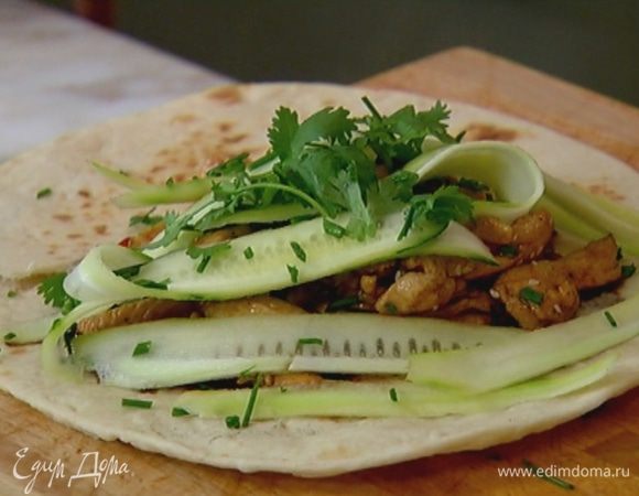 На лепешку выложить обжаренную курицу, шнитт-лук и полоски огурца. Кинзу порвать руками и посыпать курицу с огурцами.