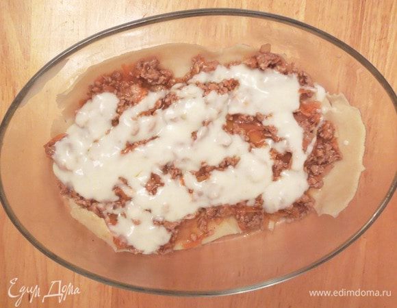 В форму для запекания поместить листы отваренного теста, перекладывая их фаршем и поливая соусом бешамель. 