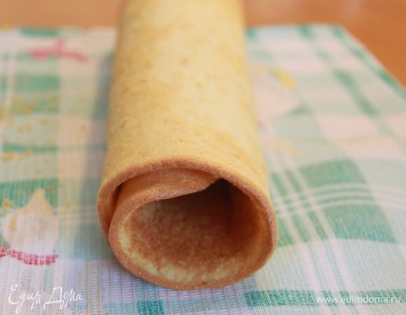 Пока бисквит горячий, сворачиваем его в рулет с помощью полотенца. Оставляем до полного остывания.