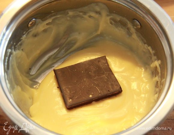 Делим крем на две равные части. В одну часть крема добавляем шоколад. 