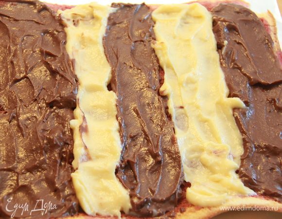 Намазываем пропитанный ликёром бисквит кремом: чередуем белый и шоколадный.