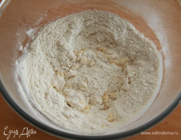 Добавляем просеянную с разрыхлителем муку, перемешиваем, замешиваем тесто.