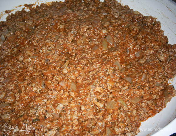 Томатное пюре добавьте к обжаренному фаршу, всыпьте итальянские травы (примерно 2 ч. л., ориентируйтесь на свой вкус). Тушите на среднем огне минут 10, чтобы испарилась лишняя жидкость.