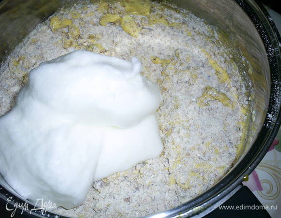 Во взбитые желтки вводим мучную смесь, и 1/4 часть взбитых белков. Все аккуратно перемешиваем лопаткой.