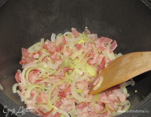 Добавить лук и жарить вместе с грудинкой до мягкости.