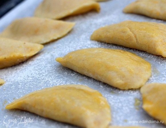 Каждый кружок смазываем желтком, разболтаным с ч. л. воды, выкладываем в середину ч. л. начинки (аккуратно, она - жидкая) и защипываем края.