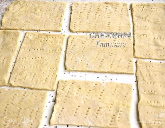Слоёное тесто раскатываем в прямоугольник, не очень тонко, где-то в 2-3 мм толщиной. Размечаем прямоугольнички 13x8 см. Переносим тесто на противень и уже там разрезаем его на прямоугольники. Накалываем тесто вилкой.