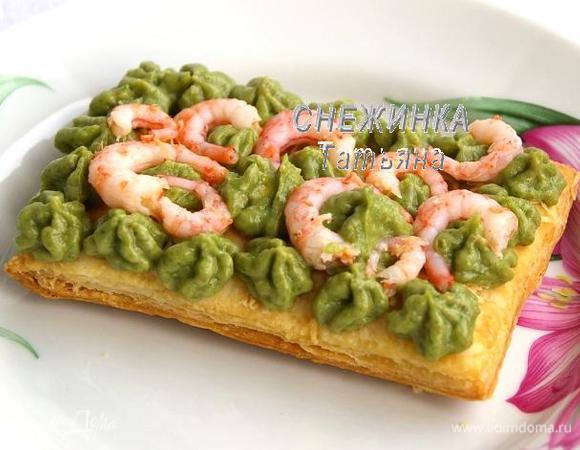 На первый слой теста выдавливаем из кондитерского мешка крем по всей поверхности. Между крема кладём креветки.