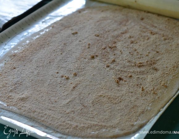 Готовое тесто выложить на поверхность с мукой. Раскатать прямоугольной формой. Поверх смазать обильно сливочным маслом комнатной тем-ры. Выложить поверх сахар с корицей.