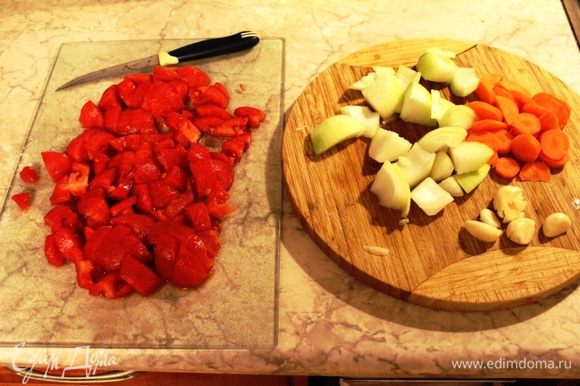 Пока мясо обжаривается, лук и морковь крупно порезать, чеснок придавить ножом. Помидоры обдать кипятком, снять кожицу и порезать средними кусочками.