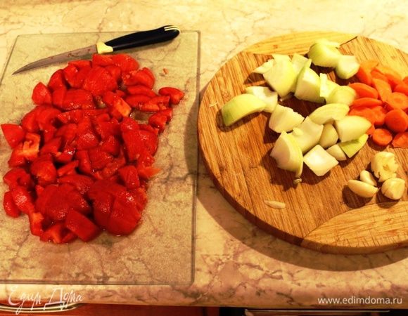 Пока мясо обжаривается, лук и морковь крупно порезать, чеснок придавить ножом. Помидоры обдать кипятком, снять кожицу и порезать средними кусочками.