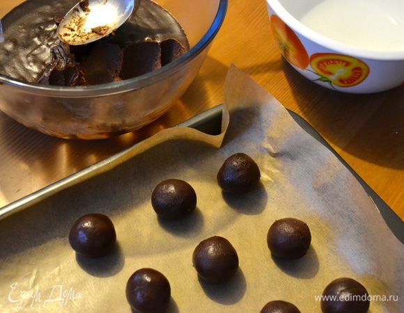 В итоге шоколадная масса должна хорошо застыть (как на фото!), ее удобно будет отделять ложкой. Из теста руками формируем небольшие ровные шарики (весом примерно 10 г) и укладываем их на небольшой поднос, покрытый пекарской бумагой. Я поначалу запаслась мисочкой с водой, чтобы смачивать руки, но этого не потребовалось! Шоколадное тесто, хоть и застывшее, но достаточно податливое и к рукам не прилипает в процессе формирования шариков.      