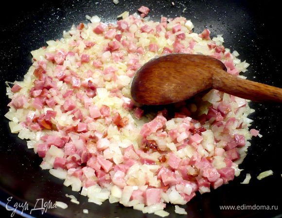 Поджарим лук с беконом в оливковом масле, добавим паприку, капусту и морковь, продолжим жарить следующие пять минут на небольшом огне. Посолим и поперчим. Приправим мелко порезанной петрушкой и натертым чесноком.