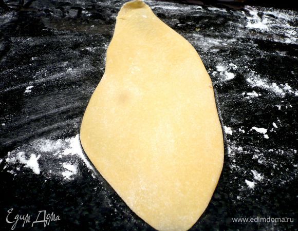 Начинку смешаем с яйцами и фаршем. Посолим, поперчим. Из теста раскатаем «колбаску» длиной примерно 30 см. Теперь каждый раз мы будем отрезать от нее кусочки шириной примерно 3 см (тесто, с которым мы не работаем, укладываем на припыленную мукой поверхность и закрываем полотенцем). На припыленной мукой поверхности прижмем отрезанный кусочек руками, чтобы получилась лепешка. Затем начнем раскатывать тесто, пока оно не станет тонким.