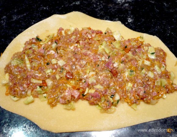 Распределяем начинку по тесту так, чтобы длинные стороны пласта перед нами были свободны примерно на 1 см от начинки.