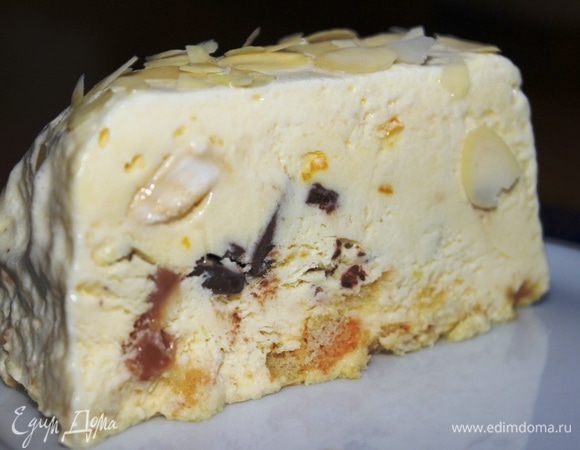 После замораживания достать десерт из формы, освободить от пленки и минут через 10 присыпать сверху миндальными лепестками.  Нарезать на порции и подавать к столу. Можно полить лимонным или шоколадным топпингом. Приятного аппетита!