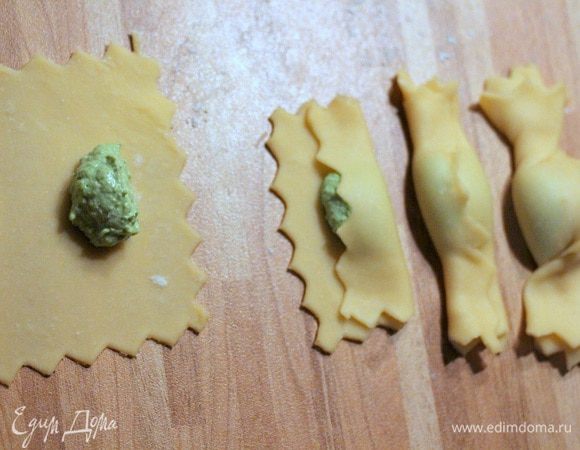 Выкладываем шарик начинки в центр прямоугольника, заворачиваем нижний край и прижимаем его так, чтобы тесто легло на начинку, накрываем верхним краем теста. Проворачиваем концы карамелли, чтобы они хорошо закрепились, по часовой стрелке один и против часовой стрелки другой. 