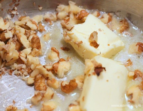 В сотейнике растапливаем сливочное масло, добавляем туда горсть мелкорубленных грецких орехов. 