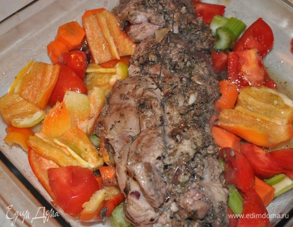 В форму выкладываем крупно нарезанные овощи и кости, отделенные вначале от ноги и  рулет. 