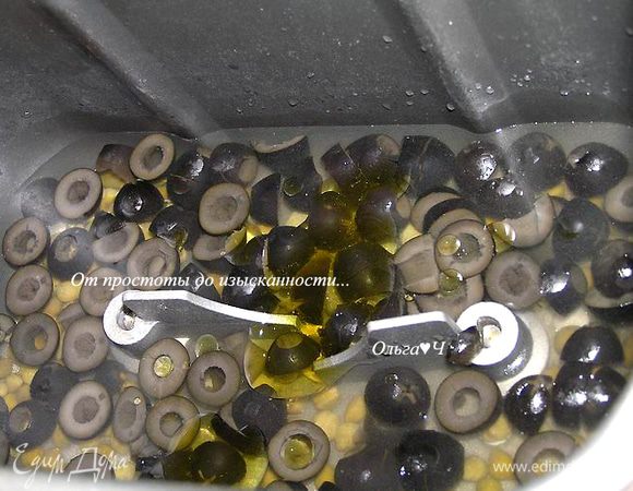 В контейнер хлебопечки налить воду, добавить соль, оливковое масло, каперсы и нарезанные маслины.