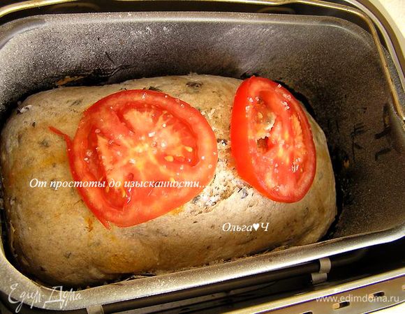 Включить хлебопечку, выбрать программу "Хлеб из цельной муки", вес 1500 г и светлый цвет корочки. Нажать кнопку "Старт". За 30-40 минут до окончания приготовления хлеба, смазать поверхность оливковым маслом, выложить ломтики помидора и посыпать солью.