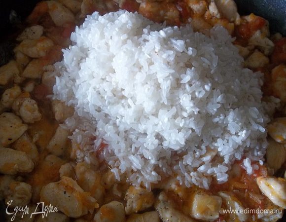 Добавляем ещё немного оливкового масла, соль, перец, базилик или любимую приправу, выдавливаем чеснок, засыпаем рис и обжариваем 2 минуты, хорошо помешивая.