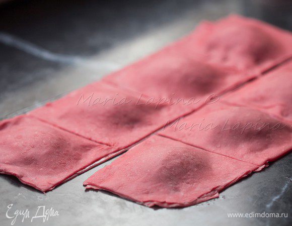 Разрезаем на квадраты, присыпаем мукой и прижимаем края каждого равиоли. 