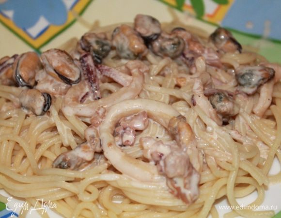 На блюдо выложить спагетти, сверху морепродукты и полить сырно-сливочным соусом.