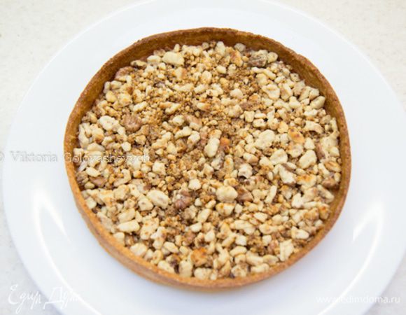 На основу выложить крупно порубленные и слегка поджаренные грецкие орехи.