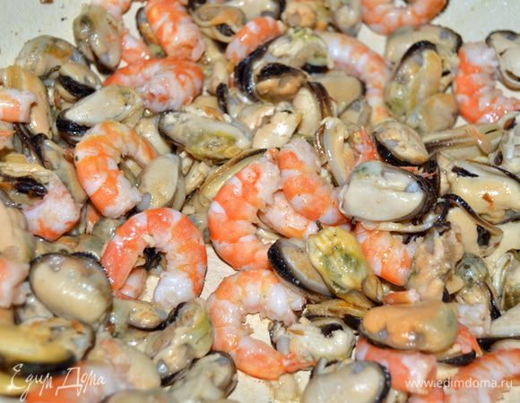 Спагетти отварить,как указано на упаковке.На сковороде разогреть оливковое масло,добавить раздавленный зубчик чеснока.Выложить креветки с мидиями.Слегка обжарить.