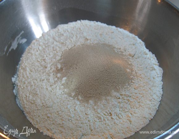 Просеять муку. К муке добавить соль, сахар, дрожжи и перемешать.   