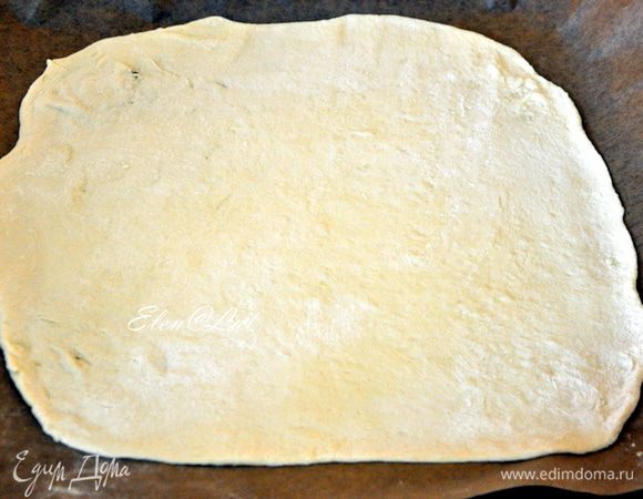Тесто разделить на две равные части и одну раскатать, достаточно тонко. Поместить пласт на противень, застеленный пергаментом.
