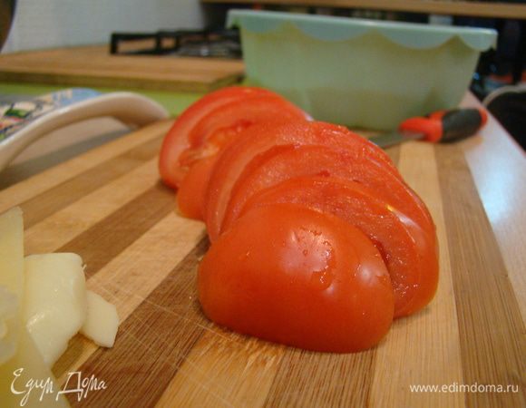 Нарезать тонкими пластинами помидоры, выстелить в форму на сыр, подсолить.