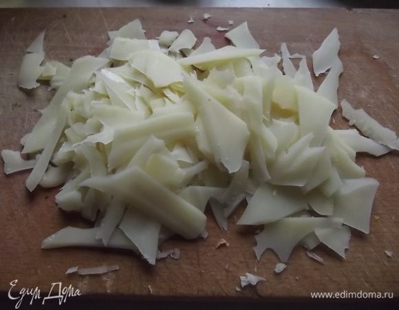 Пармезан натереть на терке длинными хлопьями.