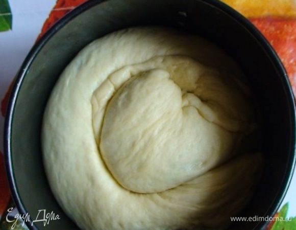 Высокую разъемную форму для выпечки смазать маслом (если форма не разъемная – выложить промасленным пергаментом дно и стенки формы). Рулет свернуть в кольцо и положить в форму.