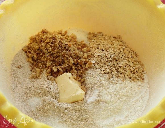 Грецкие орехи подсушите в духовке или в микроволновке 1,5 минуты на 600 Вт., остудите, крупно порубите, добавьте просеянную муку, овсяные хлопья, добавьте соль и сахар, мягкое масло.