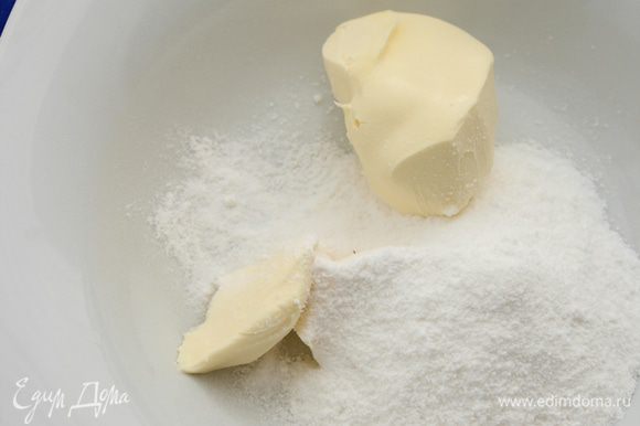 Пока тесто в холодильнике, приготовить миндальный крем. В глубокую тарелку положить сливочное масло комнатной температуры и высыпать сахарную пудру. Хорошо ложкой перемешать ингредиенты до получения однородной массы.