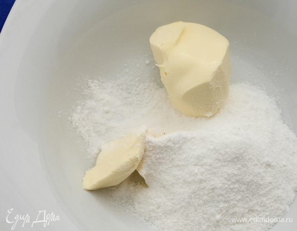 Пока тесто в холодильнике, приготовить миндальный крем.
В глубокую тарелку положить сливочное масло комнатной температуры и высыпать сахарную пудру. Хорошо ложкой перемешать ингредиенты до получения однородной массы.
