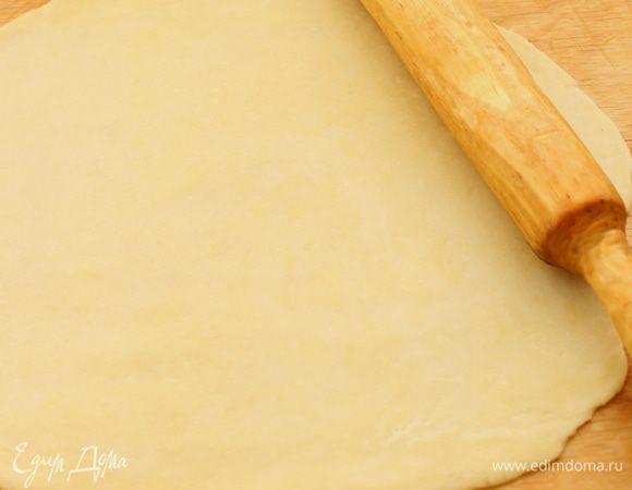 Охлажденное тесто достать из холодильника и разделить на 2 части. Каждую часть теста раскатать в скалкой в пласт, придавая ему округлую форму, диаметром около 25 сантиметров. 
Удобнее, конечно же, раскатывать тесто и формировать пирог сразу на бумаге для выпечки. Со вторым я так и поступила.
