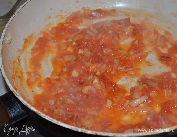 Лук и чеснок мелко нарезать, спасеровать. Добавить рубленые томаты, довести до кипения и немного уварить.