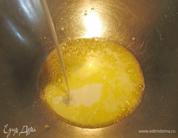 Миску со сливочным маслом поставить на огонь и растопить. В масло влить  200 г молока. 