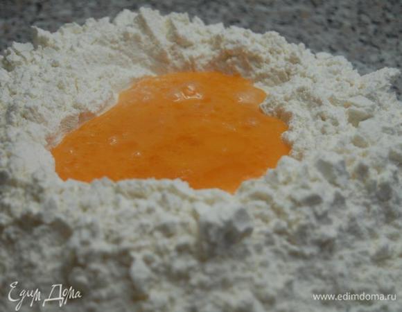 В пиале легонько смешать яйца + оливковое масло + вода +соль. Муку горкой просеять на стол, в центре сделать углубление и влить в него приготовленную смесь.