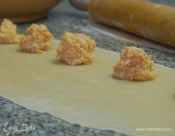 Тесто разделить на три части и раскатать в длинные прямоугольники толщиной до 2мм, с одной стороны (отступите от края несколько см) выложить начинку с  небольшими промежутками 