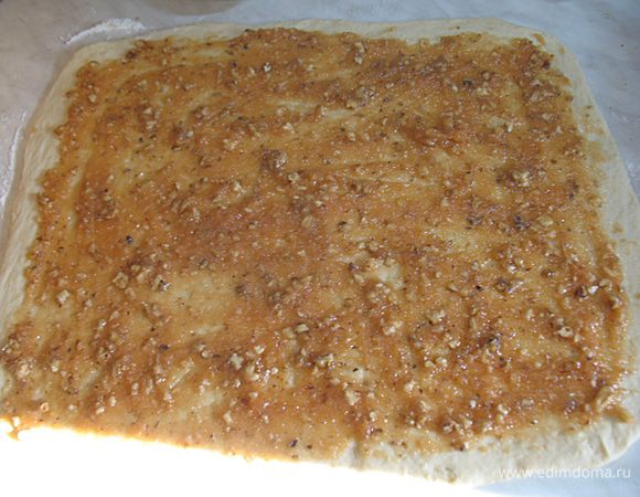 Раскатать тесто в прямоугольник толщиной около 3мм. Намазать смесью конфитюра и орехов, оставляя границу 1см со всех сторон.