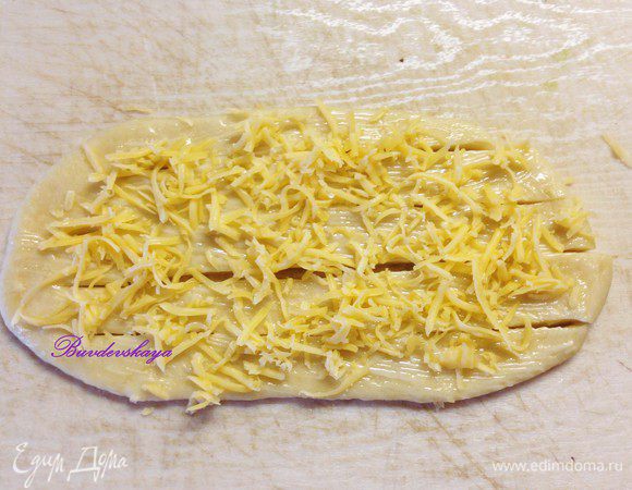 Смазать нашу заготовку растопленным сливочным маслом и немного посыпать сыром.