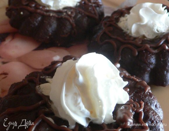 Переложить остывшие кексы на тарелку. Растопить молочный шоколад на водяной бане, наполнить растопленным шоколадом кондитерский шприц, украсить кексы произвольным узором.  Взбить сливки и выложить ложкой или из кондитерского мешочка в центр колечек. 
По желанию, можно украсить пластинами порезанных ягод клубники.

Приятного аппетита!!! :)