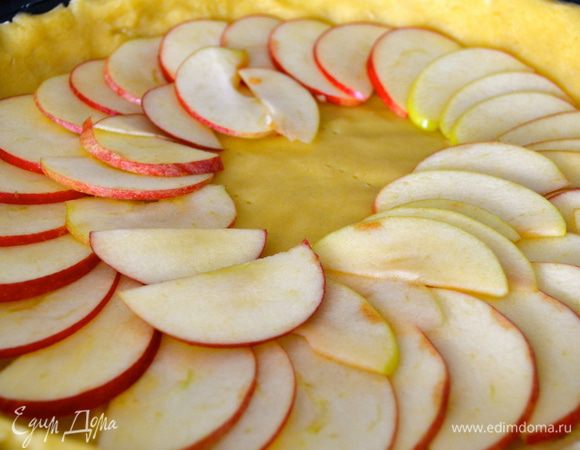 Духовку включить на 180 С. Все ингредиенты для заливки положить в небольшую кастрюльку. Быстро перемешать венчиком и поставить на огонь буквально на 3 минуты, постоянно помешивая. Заливка не должна загустеть или тем более закипеть, а лишь прогреться примерно до 40 С. Теперь достать их холодильника форму с тестом и выложить поверх яблоки...