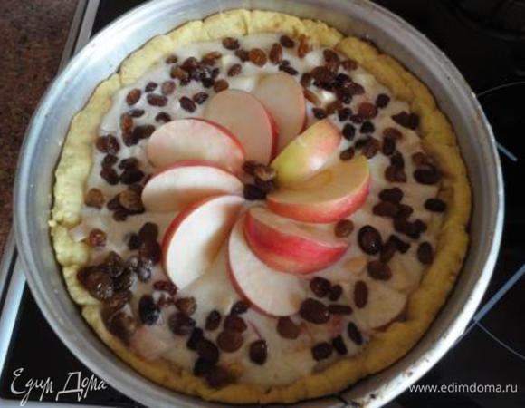 Дно готового теста посыпать ложкой крахмала и вылить начинку. В центре выложить дольки яблока в виде цветочка и по краям посыпать изюм (предварительно слив остатки коньяка). Выпекать 20 минут при температуре 190 градусов.