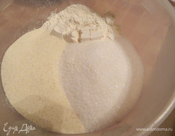 Духовку предварительно нагреть до 180 градусов. В емкость насыпать сухими муку, сахар, манку, корицу и разрыхлитель, перемешать